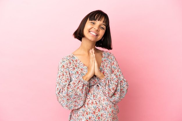 Foto jovem mulher grávida sobre fundo rosa isolado mantém as palmas das mãos juntas. pessoa pede algo