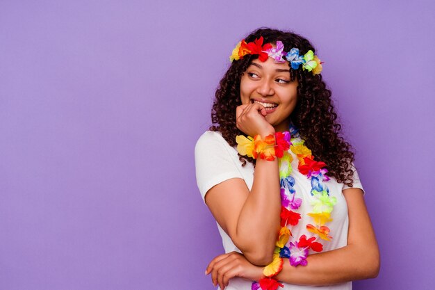 Jovem mulher havaiana isolada na parede roxa relaxou pensando em algo olhando para um espaço de cópia.