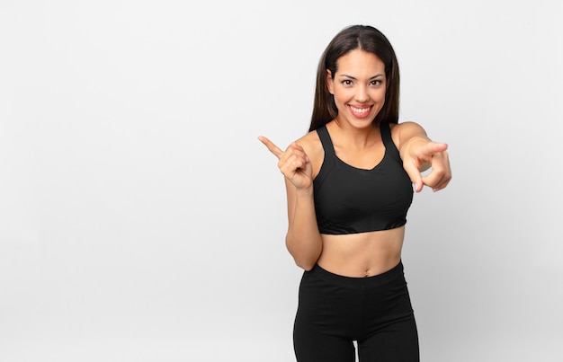 Jovem mulher hispânica, apontando para a câmera escolhendo você. conceito de fitness