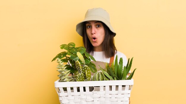 Jovem mulher hispânica com conceito de jardinagem de plantas