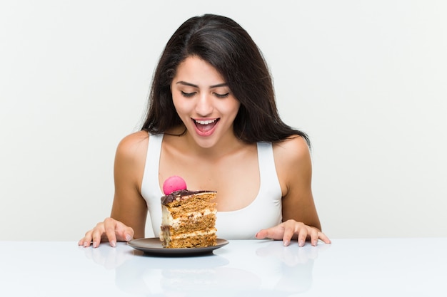 Jovem mulher hispânica, comer um bolo de cenoura