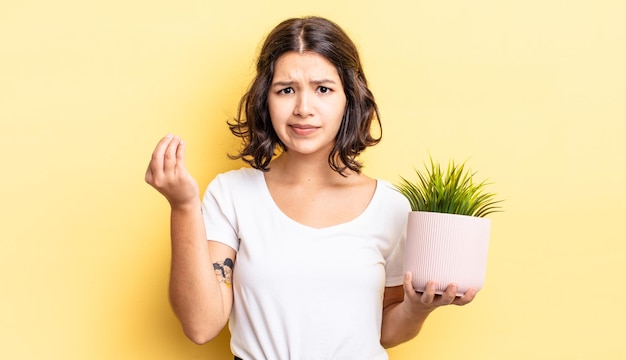 Jovem mulher hispânica fazendo capice ou gesto de dinheiro, dizendo para você pagar. conceito de crescimento