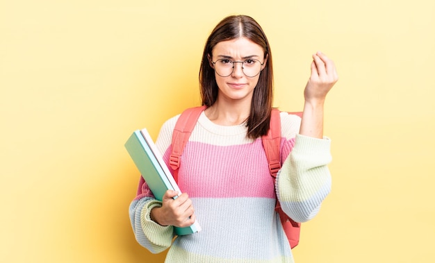 Jovem mulher hispânica fazendo gesto capice ou dinheiro, dizendo para você pagar. conceito de estudante