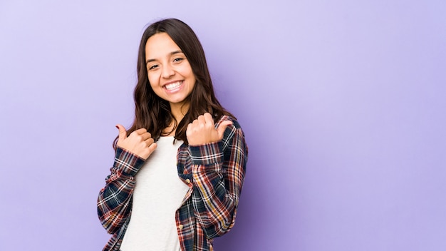 Jovem mulher hispânica, levantando os dois polegares, sorrindo e confiante.