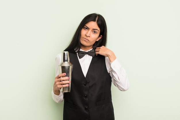 Jovem mulher hispânica olhando arrogante conceito de barman de coquetel positivo e orgulhoso bem sucedido