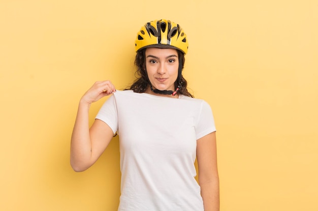 Jovem mulher hispânica olhando arrogante conceito positivo e orgulhoso de bicicleta bem-sucedida