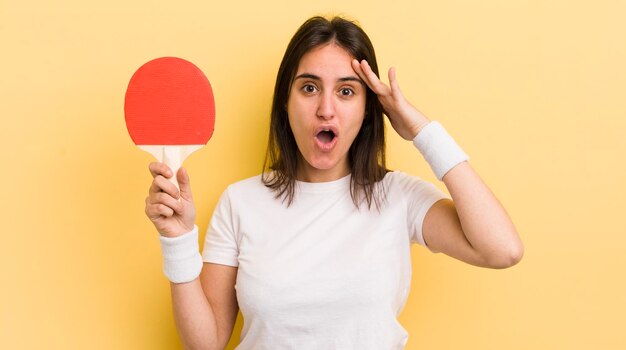 Jovem mulher hispânica olhando feliz, surpreso e surpreso conceito de pingue-pongue