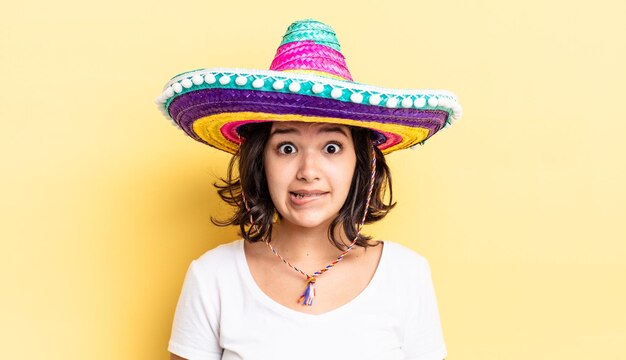 Jovem mulher hispânica olhando o conceito de chapéu mexicano confuso e confuso