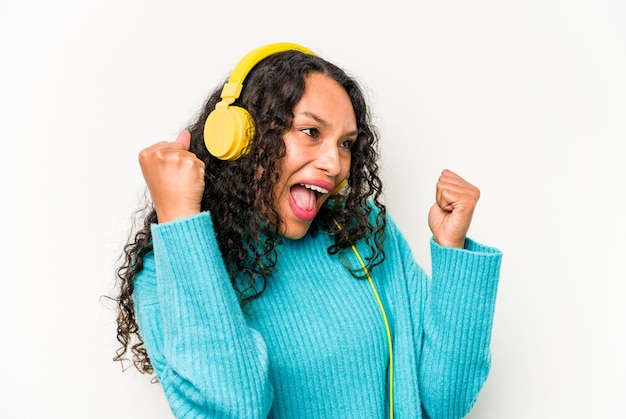 Jovem mulher hispânica ouvindo música isolada no fundo branco