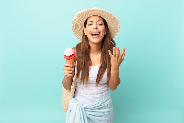 Jovem mulher hispânica parecendo desesperada, frustrada e estressada e segurando um sorvete. conceito de sumer