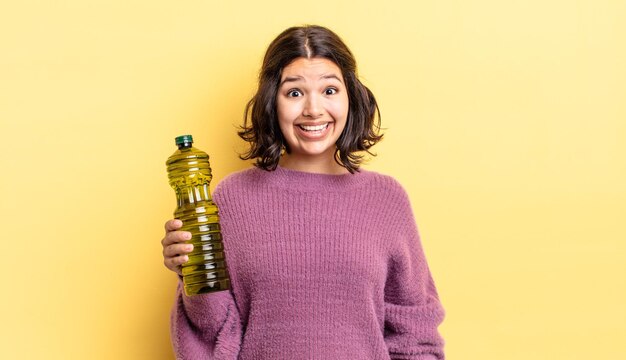 Jovem mulher hispânica parecendo feliz e agradavelmente surpresa. conceito de azeite