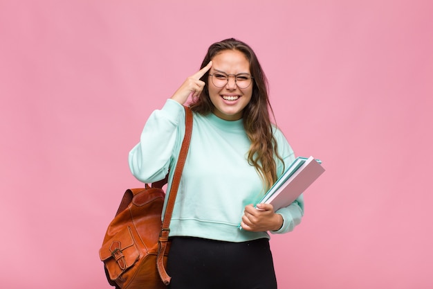 Jovem mulher hispânica parecendo surpresa, boquiaberta, chocada, percebendo um novo pensamento, ideia ou conceito