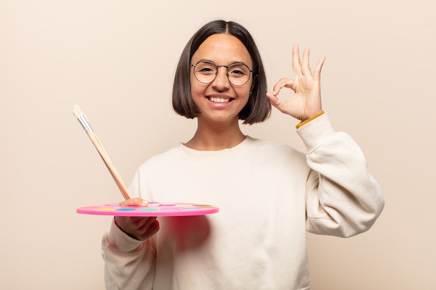 Jovem mulher hispânica se sentindo chocada, animada e feliz, rindo e comemorando o sucesso, dizendo uau!