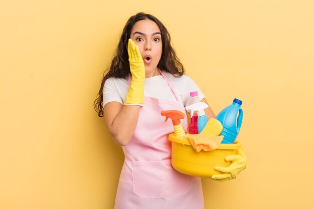 Jovem mulher hispânica se sentindo chocada e assustada com o trabalho doméstico um conceito de produtos limpos