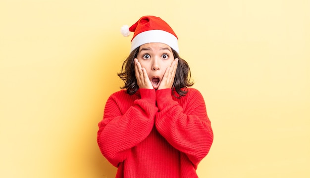 Jovem mulher hispânica se sentindo chocada e com medo. conceito de natal