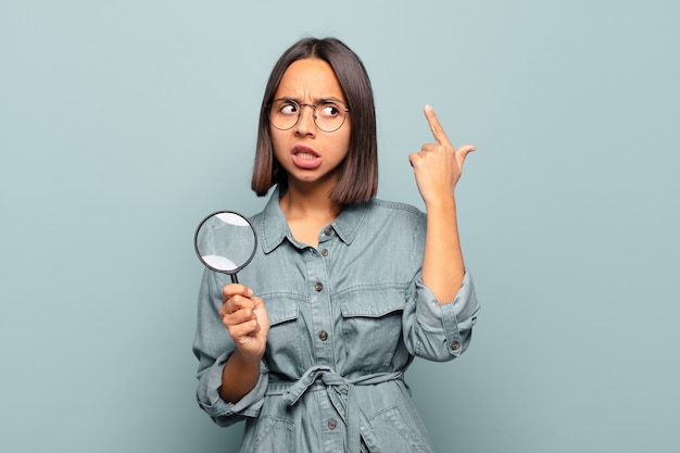 Foto jovem mulher hispânica se sentindo confusa e perplexa, mostrando que você é louco, louco ou maluco