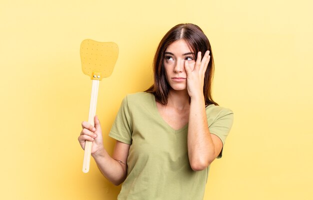 Jovem mulher hispânica se sentindo entediada, frustrada e com sono depois de um cansativo. conceito de matar moscas