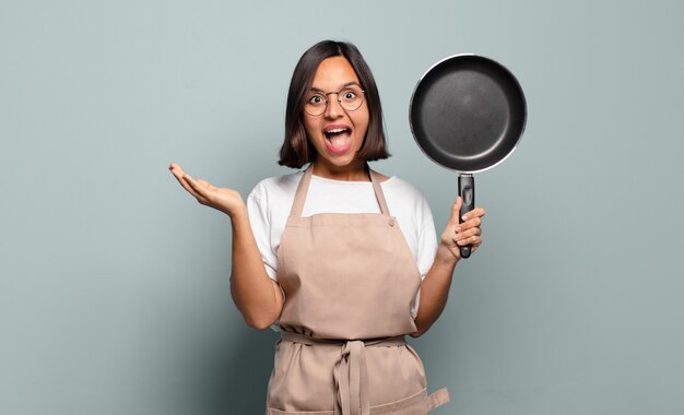 Jovem mulher hispânica se sentindo feliz, animada, surpresa ou chocada, sorrindo e atônita com algo inacreditável