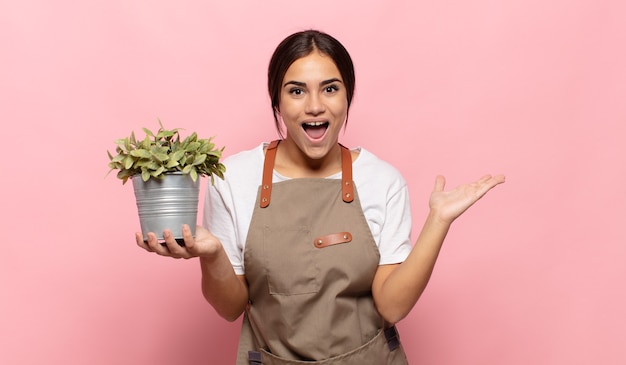 Jovem mulher hispânica se sentindo feliz, animada, surpresa ou chocada, sorrindo e espantada com algo inacreditável