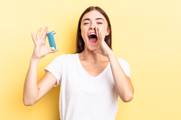 Jovem mulher hispânica se sentindo feliz, dando um grande grito com as mãos perto da boca. conceito de asma