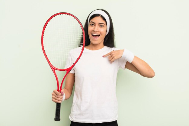 Jovem mulher hispânica se sentindo feliz e apontando para si mesmo com um conceito de tênis animado