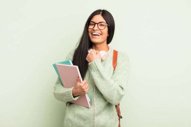 Jovem mulher hispânica se sentindo feliz e enfrentando um desafio ou comemorando. conceito de estudante