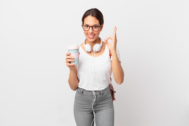 Foto jovem mulher hispânica se sentindo feliz, mostrando aprovação com um gesto certo. conceito de estudante