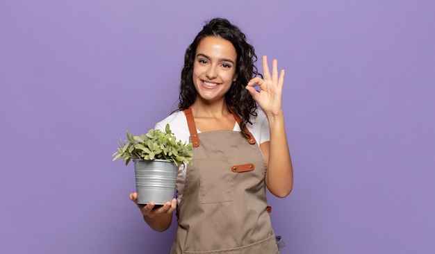 Jovem mulher hispânica se sentindo feliz, relaxada e satisfeita, mostrando aprovação com um gesto de ok, sorrindo