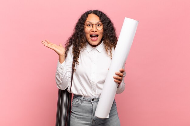 Jovem mulher hispânica se sentindo feliz, surpresa e alegre, sorrindo com atitude positiva, percebendo uma solução ou ideia