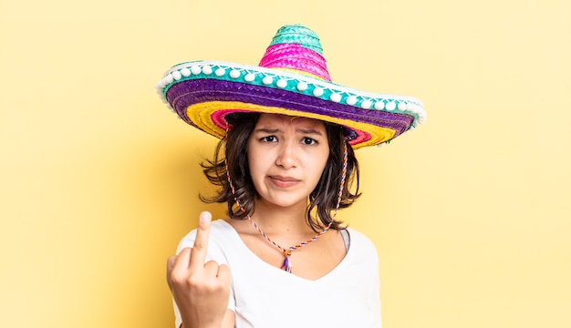 Jovem mulher hispânica se sentindo irritada, irritada, rebelde e agressiva. conceito de chapéu mexicano