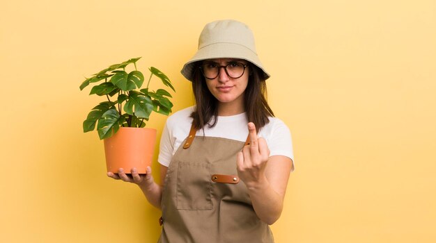 Jovem mulher hispânica se sentindo irritado irritado jardineiro rebelde e agressivo e conceito de planta