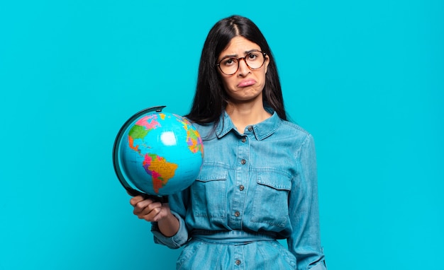 Jovem mulher hispânica se sentindo triste. conceito de planeta terra