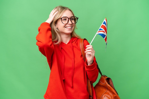 Jovem mulher hispânica segurando uma bandeira do Reino Unido sobre fundo isolado sorrindo muito