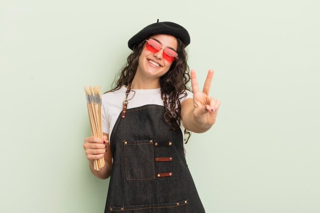 Jovem mulher hispânica sorrindo e parecendo amigável, mostrando o conceito de artista número dois