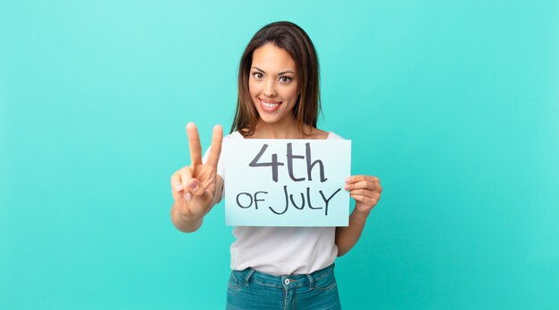 Jovem mulher hispânica sorrindo e parecendo amigável, mostrando o número dois. conceito do dia da independência