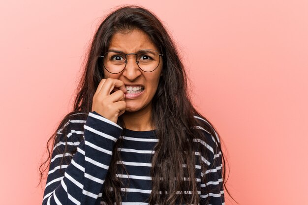 Jovem mulher indiana intelectual roer unhas, nervoso e muito ansioso