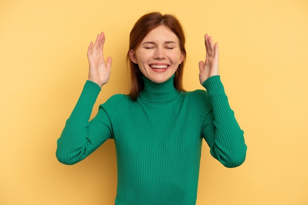 Jovem mulher inglesa isolada em fundo amarelo alegre rindo muito. Conceito de felicidade.