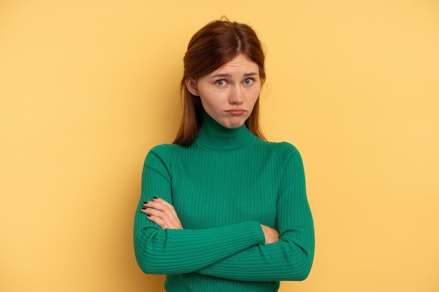 Jovem mulher inglesa isolada em fundo amarelo infeliz olhando na câmera com expressão sarcástica.