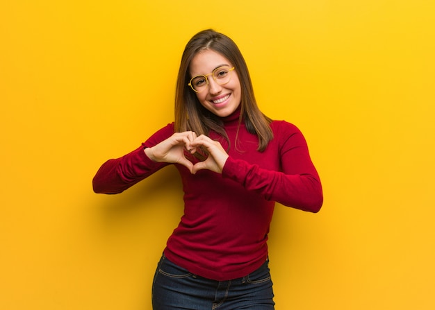 Jovem mulher intelectual fazendo uma forma de coração com as mãos