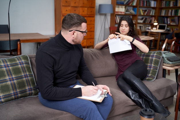 jovem mulher irritada durante psicoterapia, visitando o conceito de terapeuta