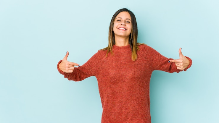 Foto jovem mulher isolada em pontos azuis para baixo com os dedos, sentimento positivo.