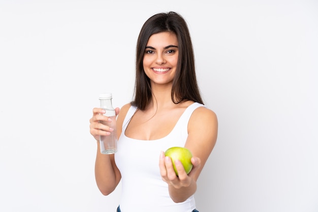 Jovem mulher isolada parede branca com uma maçã e uma garrafa de água