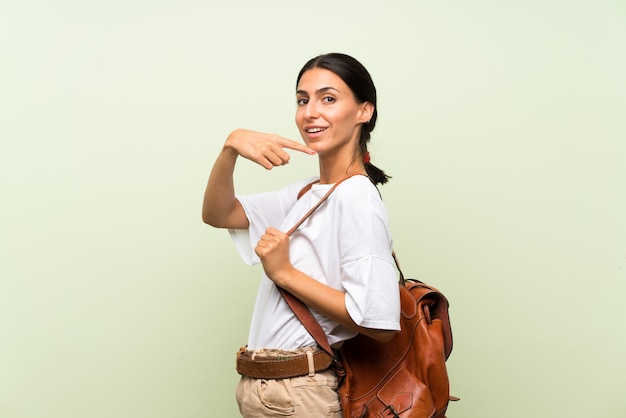 Jovem mulher isolada parede verde com mochila
