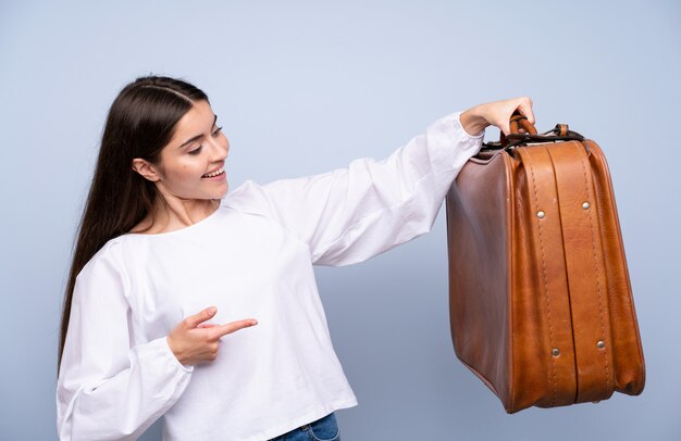 Jovem mulher isolada segurando uma maleta vintage