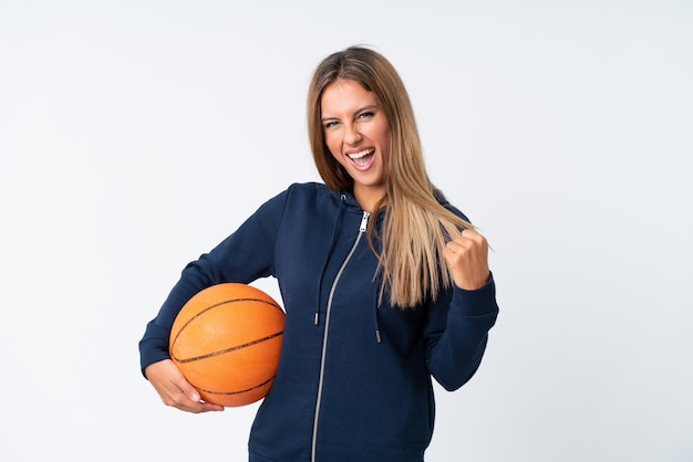 Jovem mulher jogando basquete sobre branco isolado