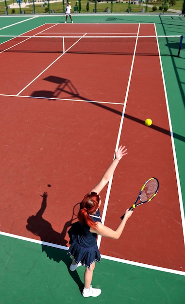 jovem mulher jogando tênis ao ar livre