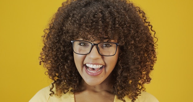 Jovem mulher latina com cabelos cacheados, feliz com seus óculos. conceito de cuidados com os olhos.