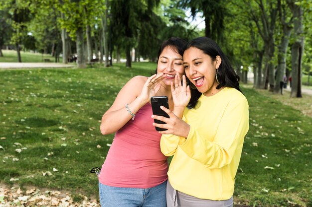 Jovem mulher latina em videochamada com smartphone com amigos realiza conferência social à distância para a Bolívia na América do Sul usando tecnologia