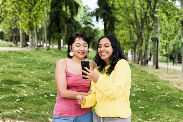 Jovem mulher latina em videochamada com smartphone com amigos realiza conferência social à distância para a Bolívia na América do Sul usando tecnologia