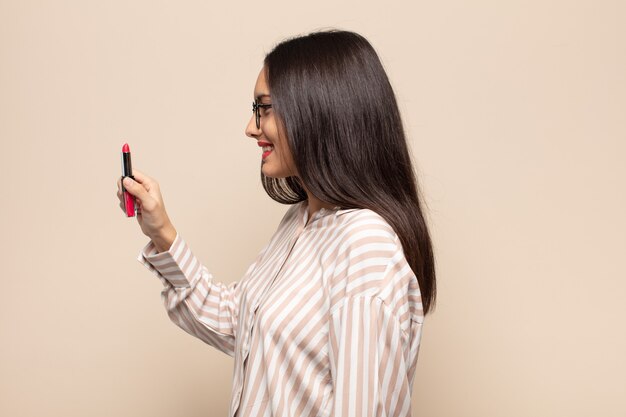 Jovem mulher latina em vista de perfil, olhando para copiar o espaço à frente, pensando, imaginando ou sonhando acordada